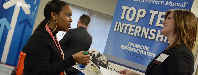 Student and employer connecting at a job fair.