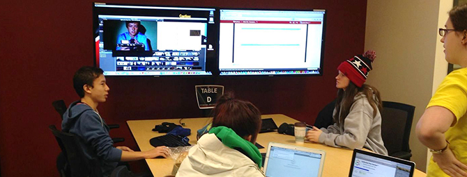 People working together at a table with screens