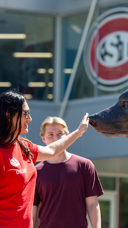 Students rubbing the nose of the Husky statue