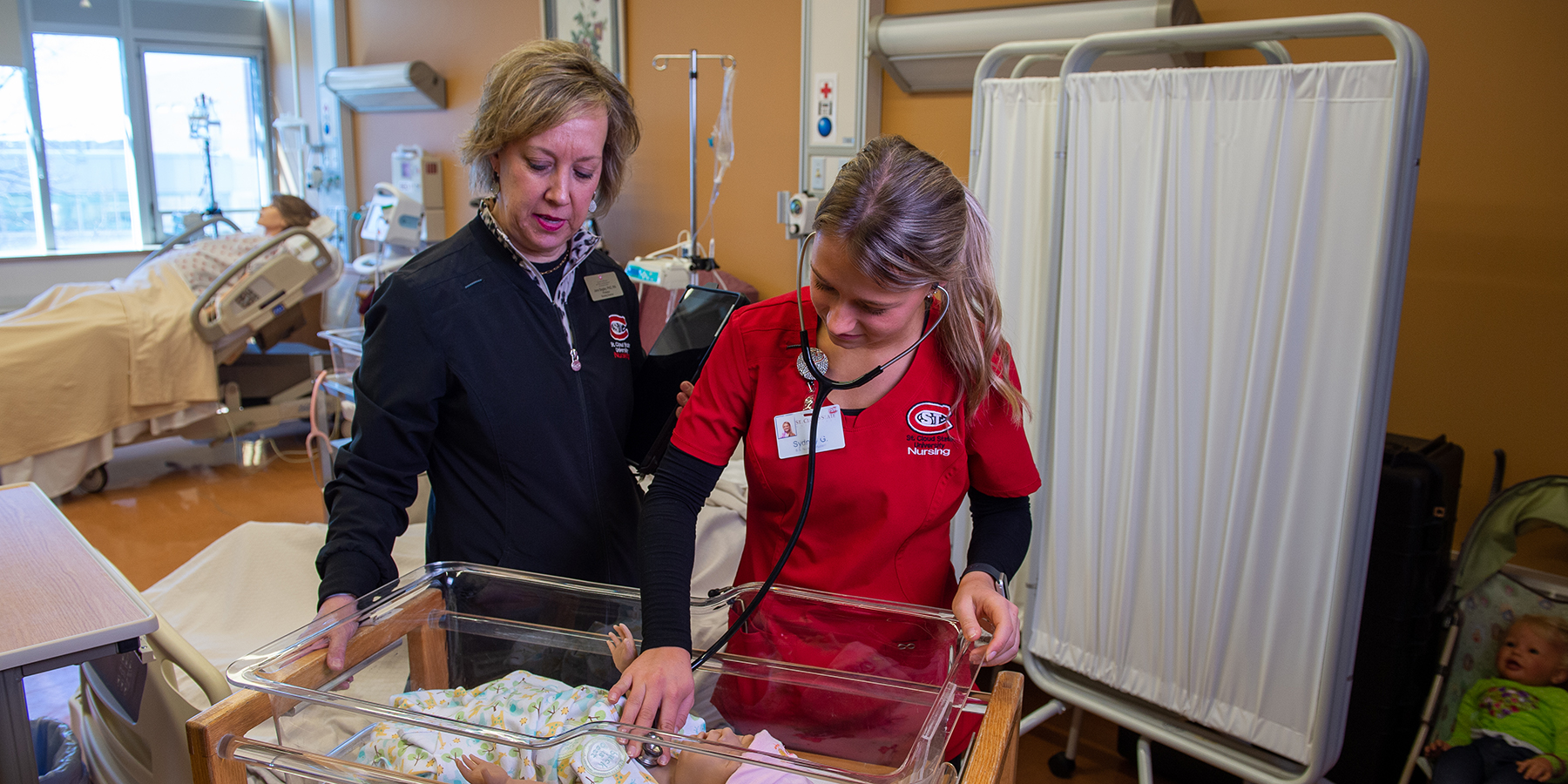 Nursing instructor and student with baby mannequin 