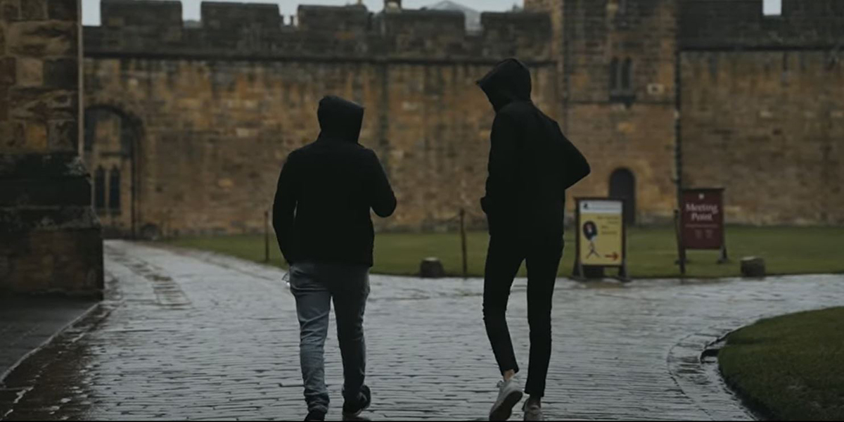Two students walking outside castle