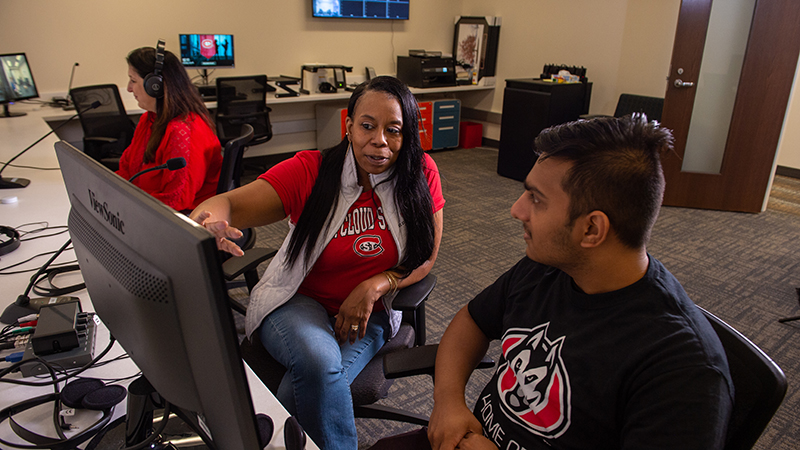 Professor and student watching counseling happen on computer monitor