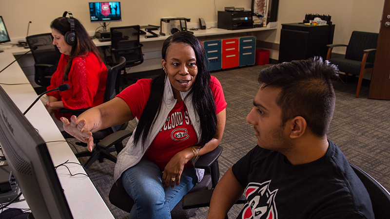 Professor speaking with student in observation lab