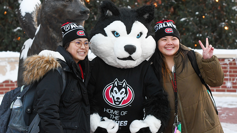 Blizzard mugging for photo with two students at Winterfest