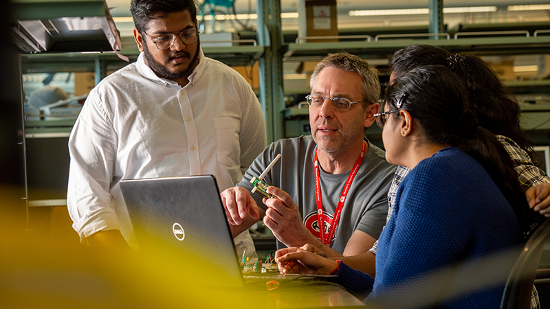 Professors working with students with electrical equipment