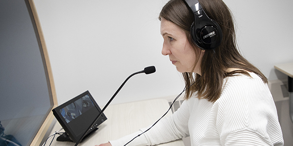 Student at observation station with monitor and headphones