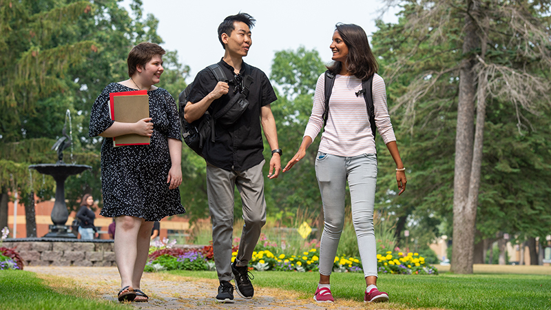 Three students walking to class through Barden Park