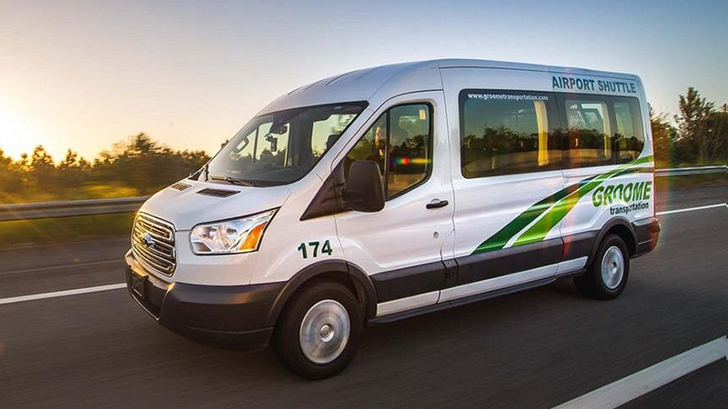 Groome Transportation shuttle van on road