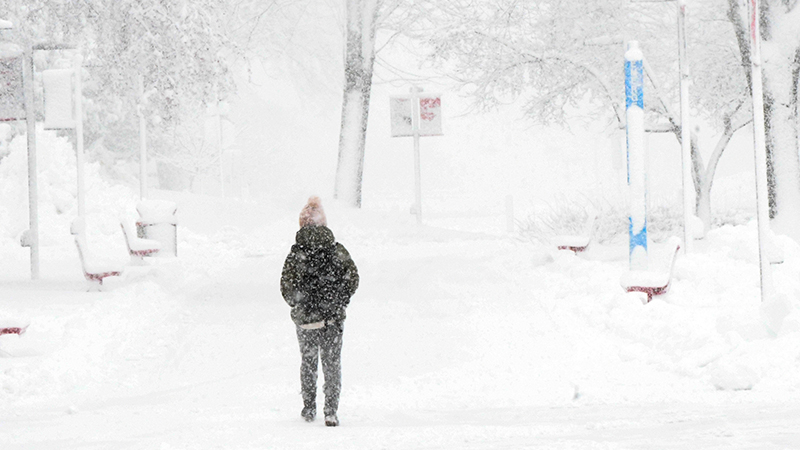 Person walking on campus during snow storm