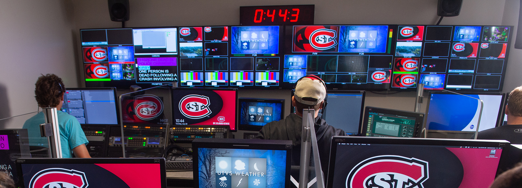 Students in control room with lots of monitors and controls