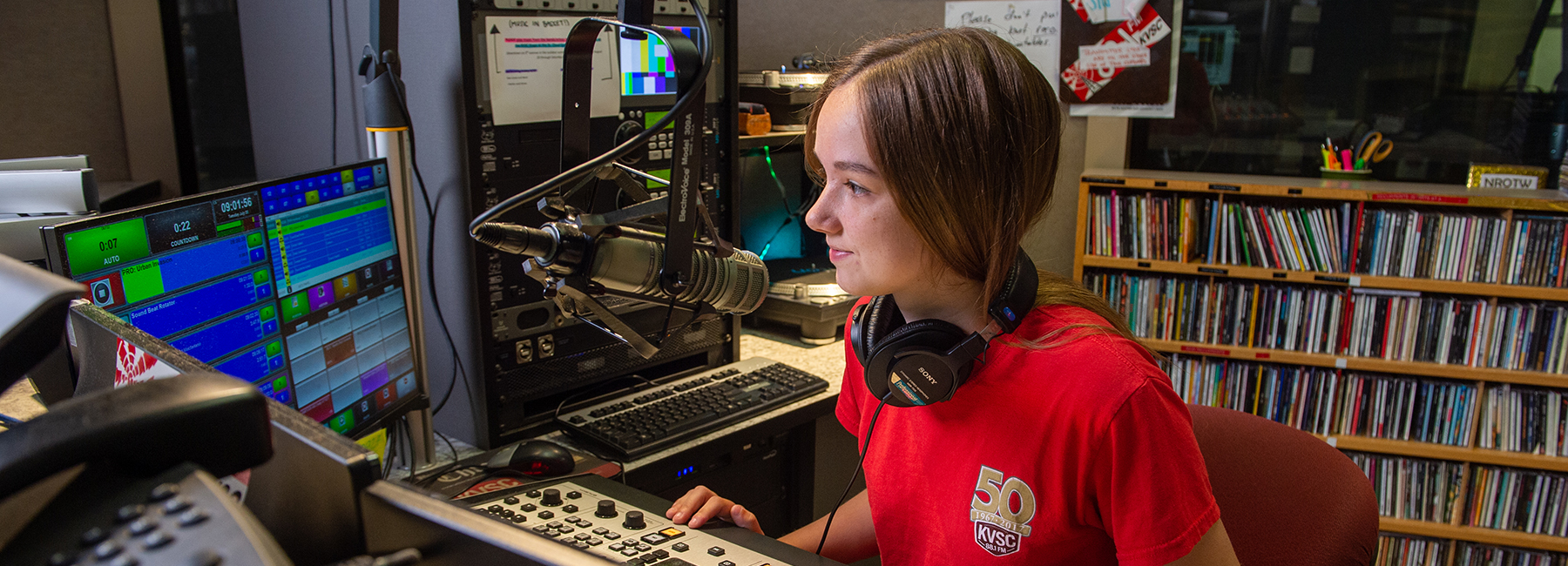 Student talking into a radio station microphone 