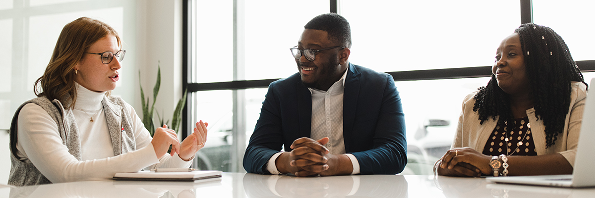 Three adult learners talking at a table