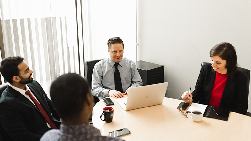 Small group seated around meeting table