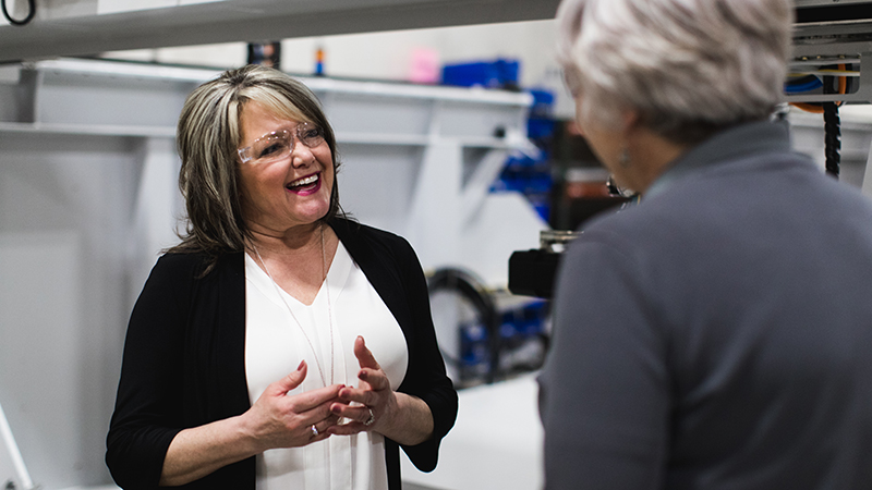 Two people talking in a manufacturing plant with eye protection on