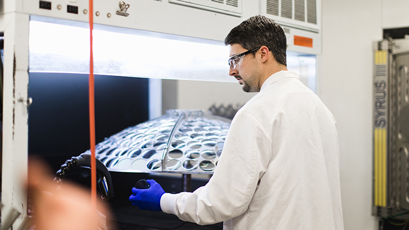 Man in lab coat working with lab equipment