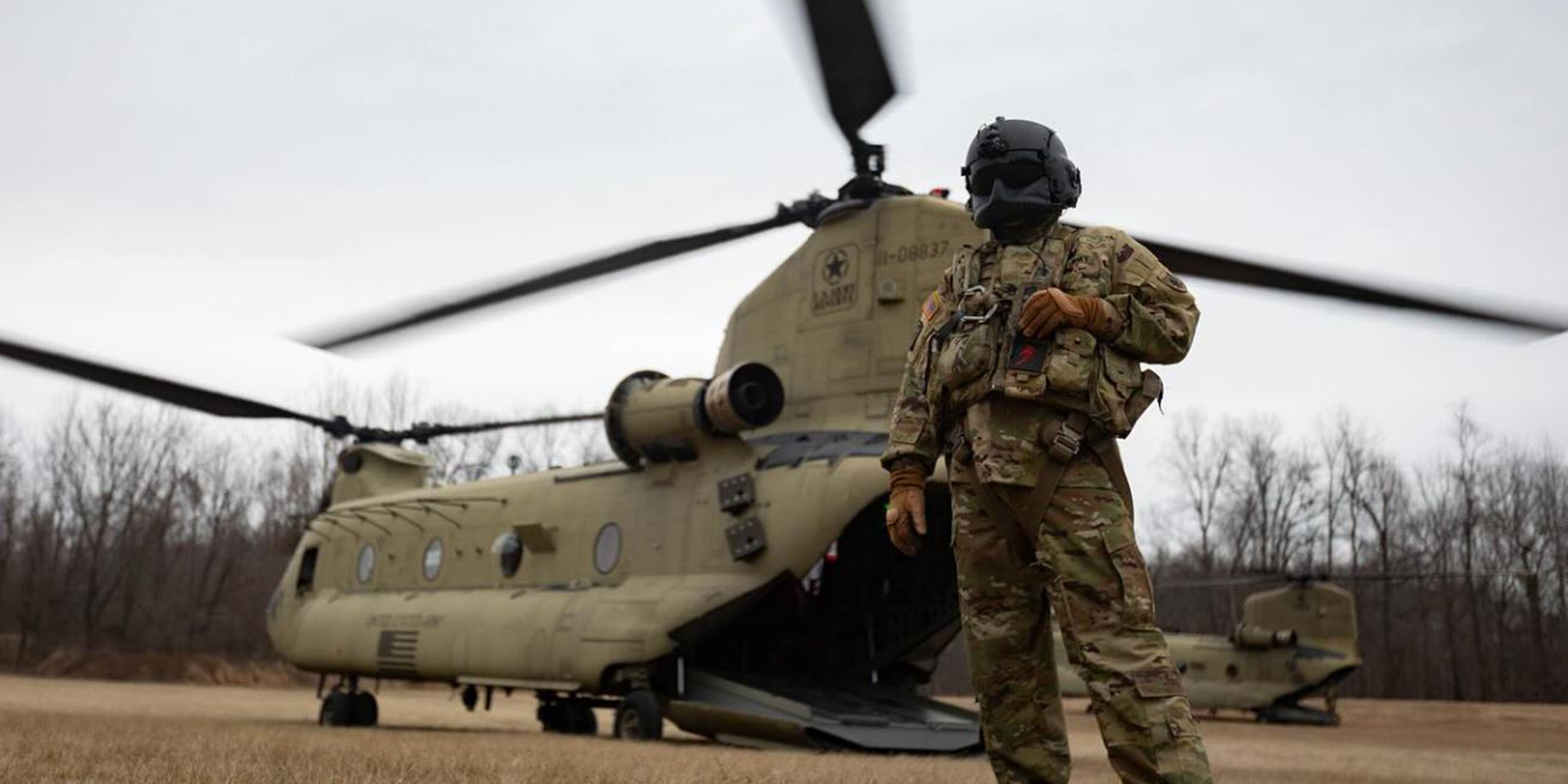 Cadet standing in front of helicopter with propellers in motion