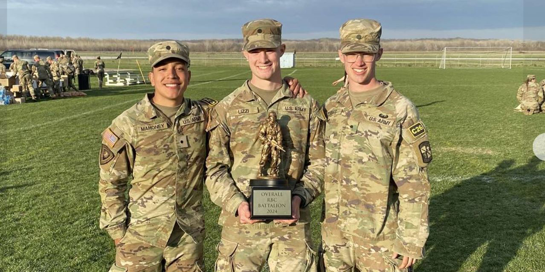 Three cadets smiling with award in hand