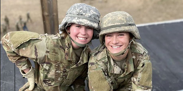 Two smiling cadets in fatigues and helmets