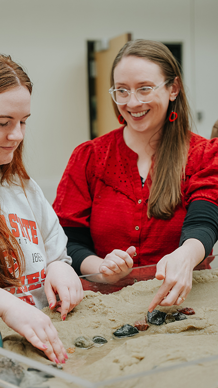 Hydrology professor working with students in a sandbox