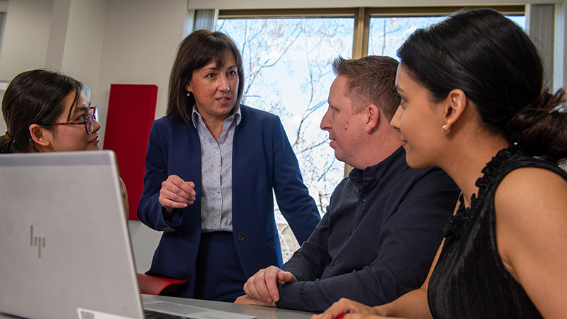 Katherina Pattit speaking to a staff member and students