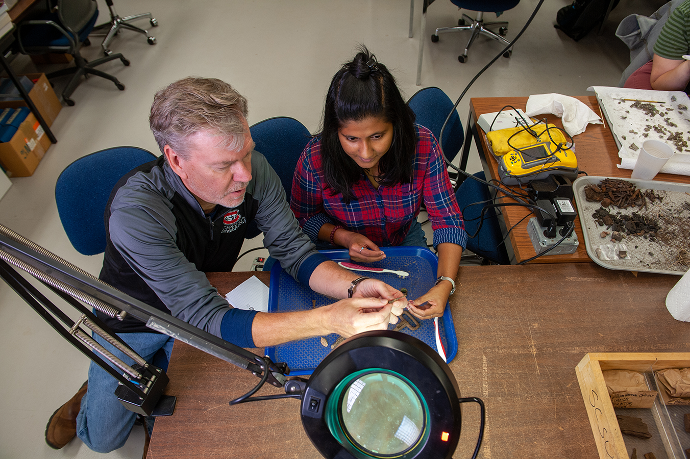 Anthropology student learning from professor in lab setting