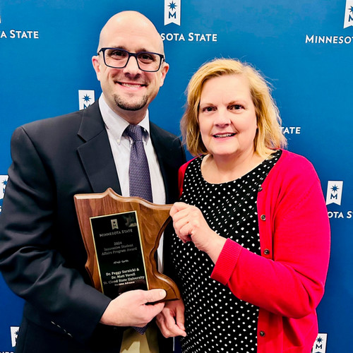 Matt Vorell and Peggy Sarnicki hold an award for HuskiesAdvance