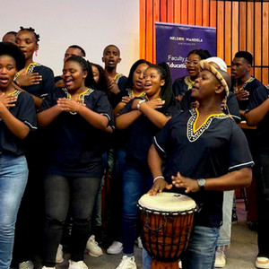 The Faculty of Education student choir signs while one students plays the drum as they perform at the ISEP Conference