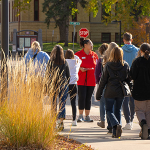 An SCSU tour guide walks a group of prospective studetns and family members across campus